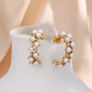 Detail of 18K gold plated hoop earrings featuring hollow design with pearls and zircons