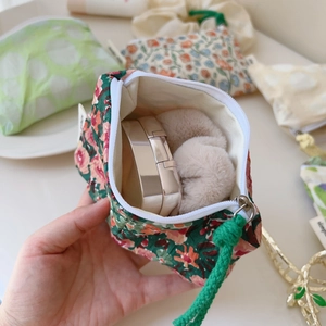 Détail de la pochette en coton à fleurs style peinture à l'huile avec cosmétiques