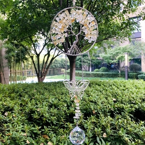 Detail of tree of life suncatcher with yellow crystal stones and a butterfly pendant