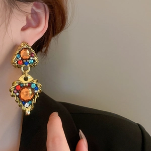 Nahaufnahme von Vintage-Herzohrringen aus Gold mit bunten Strasssteinen am Model