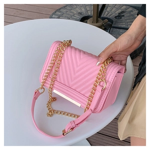 Detailed view of pink crossbody bag with V-quilted texture and gold chain strap