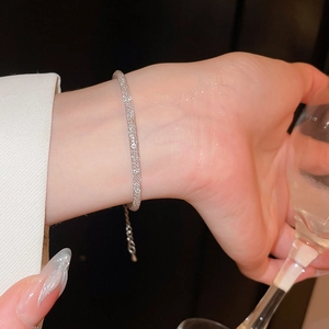 Gros plan sur l'élégant bracelet tressé argenté avec une finition scintillante