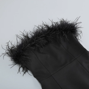 Détail de la robe bustier noire ornée de riches bordures en plumes d'autruche au décolleté