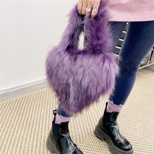 Close-up of purple heart-shaped faux fur handbag with fluffy plush texture for kids