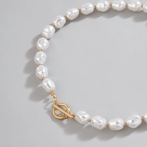 Detailed close-up of Baroque pearl necklace with elegant gold OT clasp and metal beads