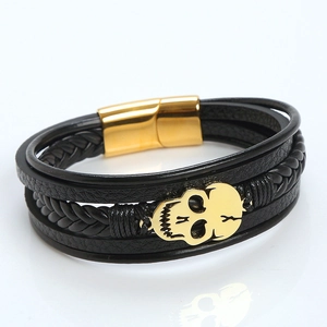 Close-up of black braided leather bracelet with gold skull detail and magnetic clasp