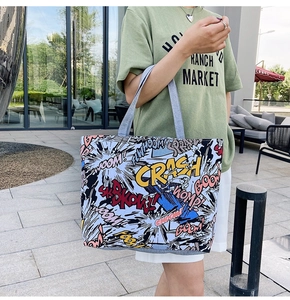Detail of canvas tote bag with colorful pop art comic prints and grey shoulder straps