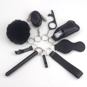 Detailed view of black multi-functional self-defense keychain set with alarm and pompom