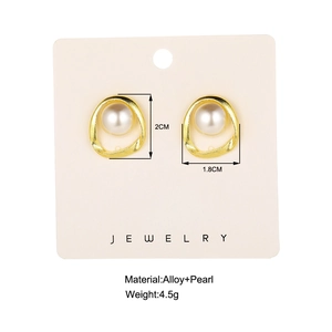 Retro irregular golden hoop earrings with central pearl on jewelry display card