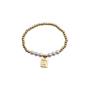 Detail of gold beaded bracelet featuring white pearls and a square letter D pendant