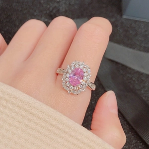 Elegant silver ring featuring an oval pink gemstone in a floral halo of white zirconias
