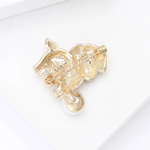 Close-up of the golden alloy puppy brooch back showing pin clasp and pearl detail