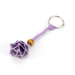 Détail d'un porte-clés artisanal en pierre de cristal violet avec filet tissé réglable