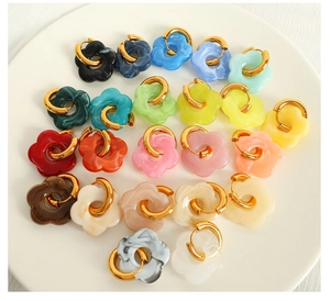 Detailed overhead view of assorted colorful resin flower hoop earrings in a white bowl