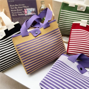 Striped knit tote bags in various colors displayed on a wooden shelf for a casual look