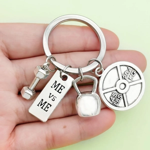 Macro view of gym keychain with dumbbell, kettlebell and Me vs Me engraved metal charms