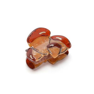 Polished amber mushroom hair claw clip with high-quality resin texture on white background