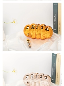 Close-up of cloud-shaped metallic acrylic clutches in gold and silver on white velvet
