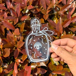 Detail of transparent suncatcher window decal featuring a mystic potion bottle design