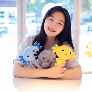 Three cute axolotl plush dolls in blue, grey and yellow held by a person by a window
