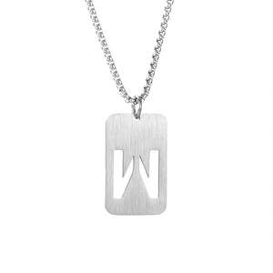 Macro shot of silver letter W cut-out pendant on a box chain stainless steel necklace