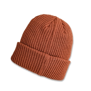 Detail of ribbed knit texture on a warm burnt orange autumn beanie hat