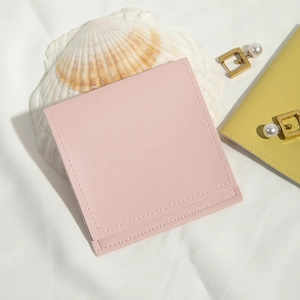 Detail of pink PU leather drawstring pouch with fine stitching on white fabric