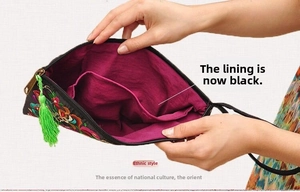 Detail view of ethnic embroidery clutch bag with black lining and silk tassel zipper