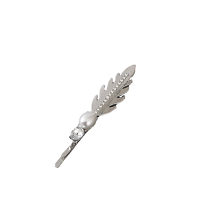 Close-up of silver feather hair clip with sparkling rhinestones and a single pearl inlay