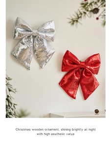 Close-up of red and silver sequin Christmas bows hanging on a white wall decor