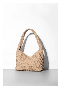 Macro della trama intrecciata e della morbida pelle PU su questa borsa hobo color beige