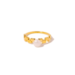 Bague élégante en titane doré en forme de cœur avec une perle blanche sur fond propre