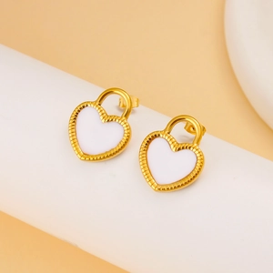 Détail de boucles d'oreilles cœur élégantes plaquées or 18 carats en émail blanc