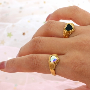Close-up of 18K gold plated braided rings featuring black and clear zircon heart stones