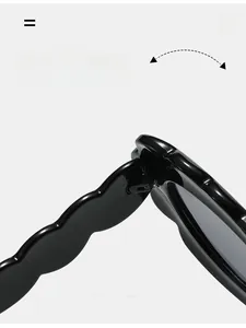 Detailed macro view showing the durable texture hinge of wavy black oval sunglasses