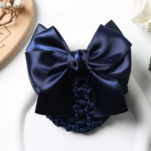 Detailed close-up of dark blue satin bow and crochet hair net for professional hairstyle
