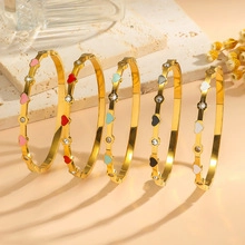 Macro shot of gold heart bangles with colorful enamel and sparkling rhinestones