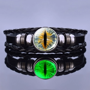Detailed view of luminous dragon eye leather bracelet with green glowing glass cabochon