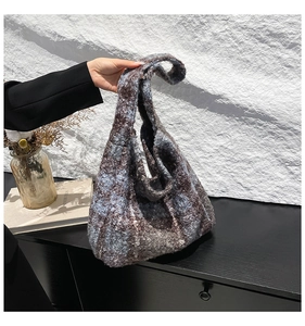 Detail of soft fuzzy blue and brown plaid tote bag with cozy sheepskin texture texture