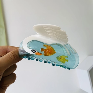 Detailed view of acetate swan hair claw clip with unique fish patterns and high texture