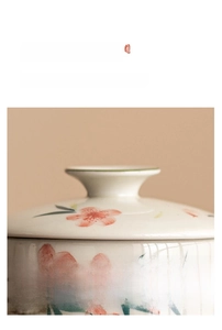 Detail of hand-painted peach blossom ceramic teacup with heat-resistant lid handle