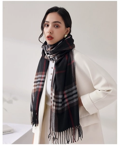 Close-up of thick plaid shawl scarf with classic red and black patterns and fringe