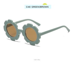 Side view of kids flower shaped sunglasses with green frames and brown lenses