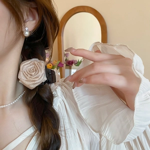 Detailansicht der eleganten beige Organza Blumen-Haarklammer mit Perlen am Modell
