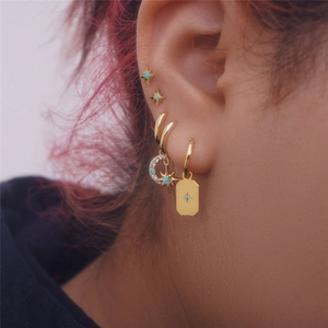 Detailed shot of S925 silver gold-plated star and moon earrings with blue opal and diamonds