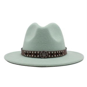 Detail of mint green fedora wool hat with brown leather band and silver metal studs