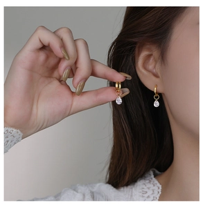 Close-up of S925 silver gold teardrop hoop earrings with clear zircon drops on ear