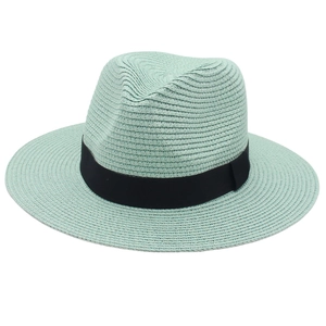 Detail of mint green straw Panama hat with black ribbon, woven texture close-up