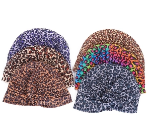 Flat lay of leopard print turban hats in purple, brown and rainbow pattern colors