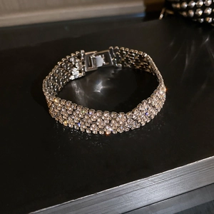 Macro shot of silver metal bangle with full pavé crystals and secure clasp detail